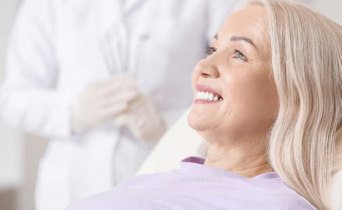 Woman with blond hair smiling in a dental chair.