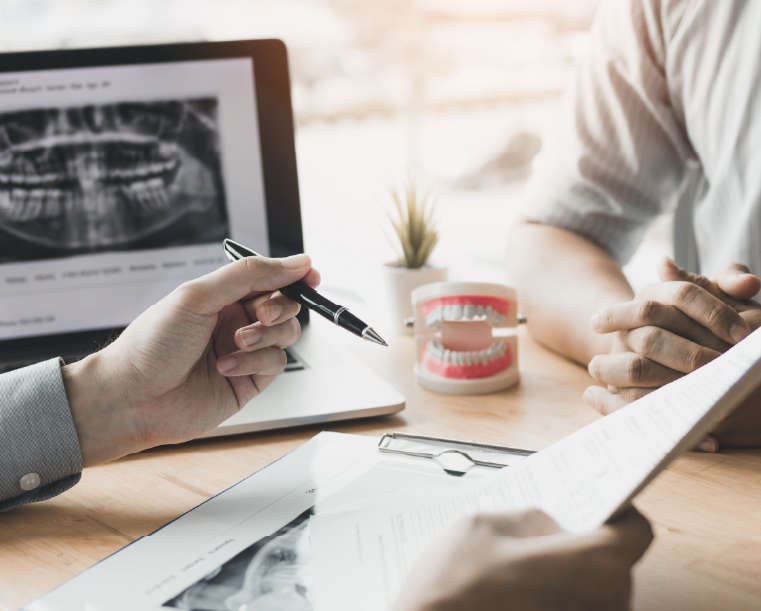 Periodontist explaining procedure with patient. Closeup of hands with pen and paper.