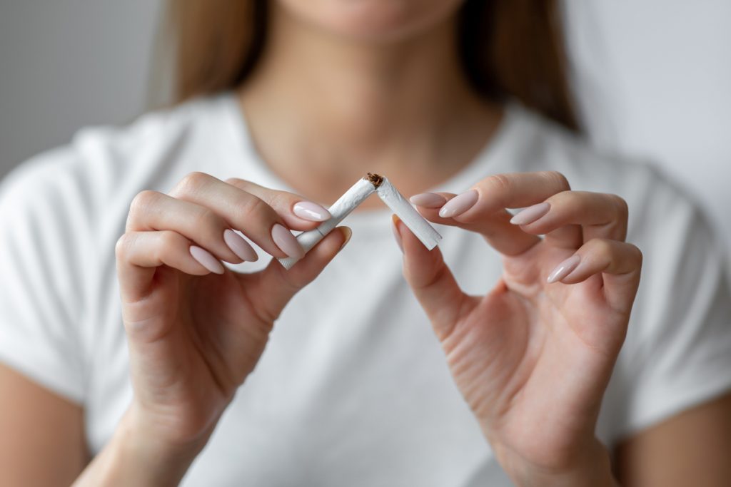 Woman quitting smoking breaks last cigarette