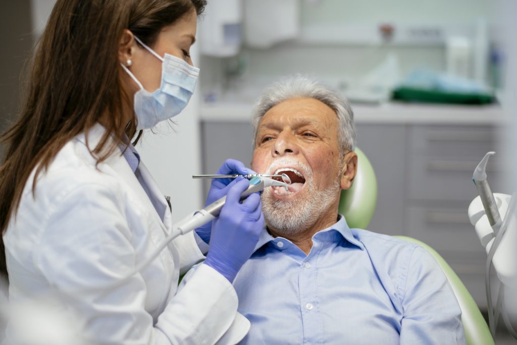 Elderly man get dental implant checked
