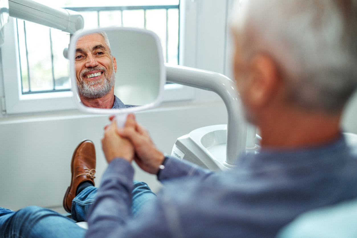 Male periodontist patient with diabetes smiling after checkup