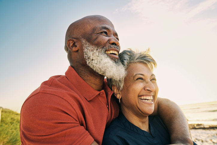 happy senior couple with healthy smiles looking out into the distances outside